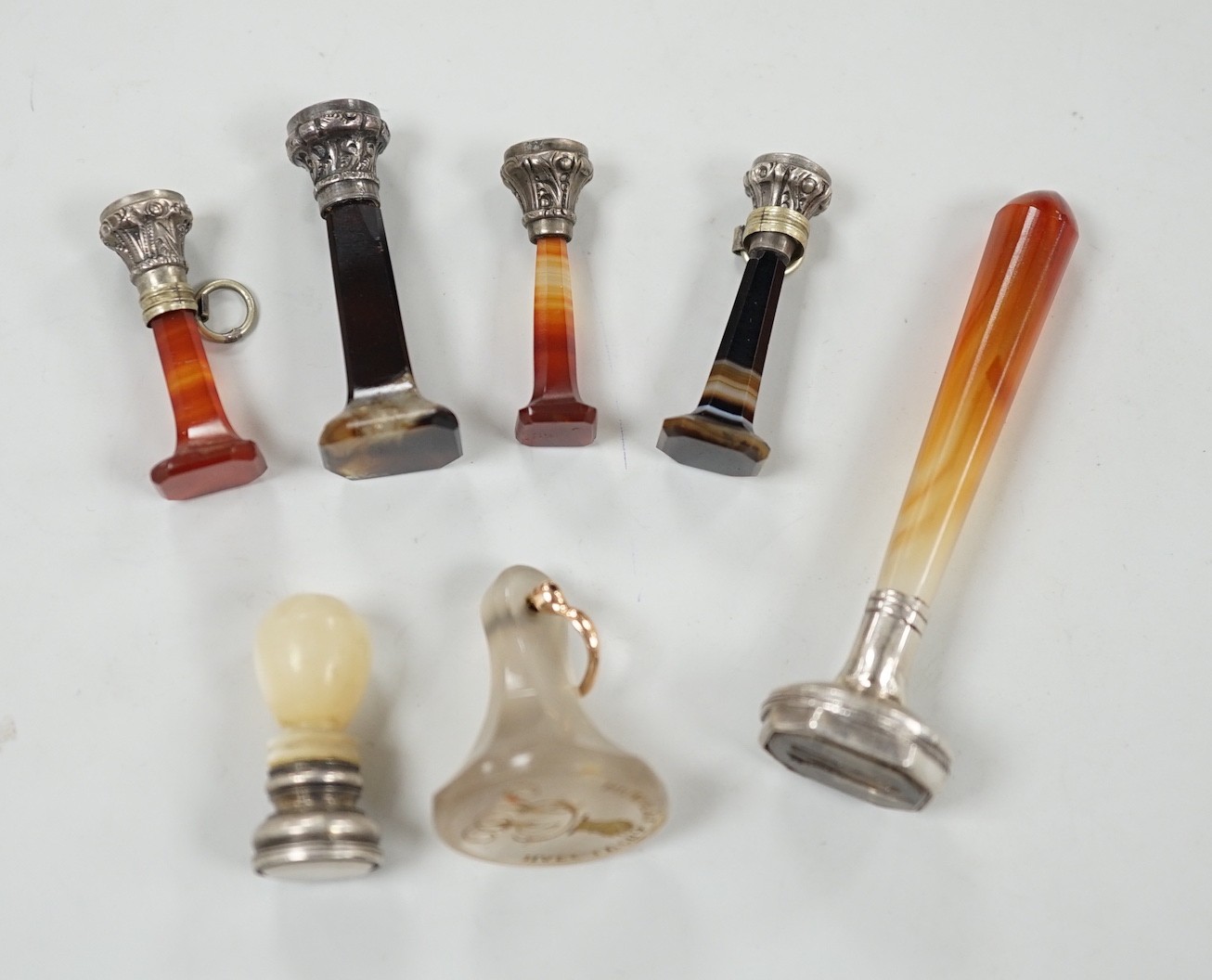 Five assorted 19th century white metal mounted agate seals, largest 61mm, a similar white metal and mother of pearl mounted seal and a white chalcedony seal with monogrammed matrix.